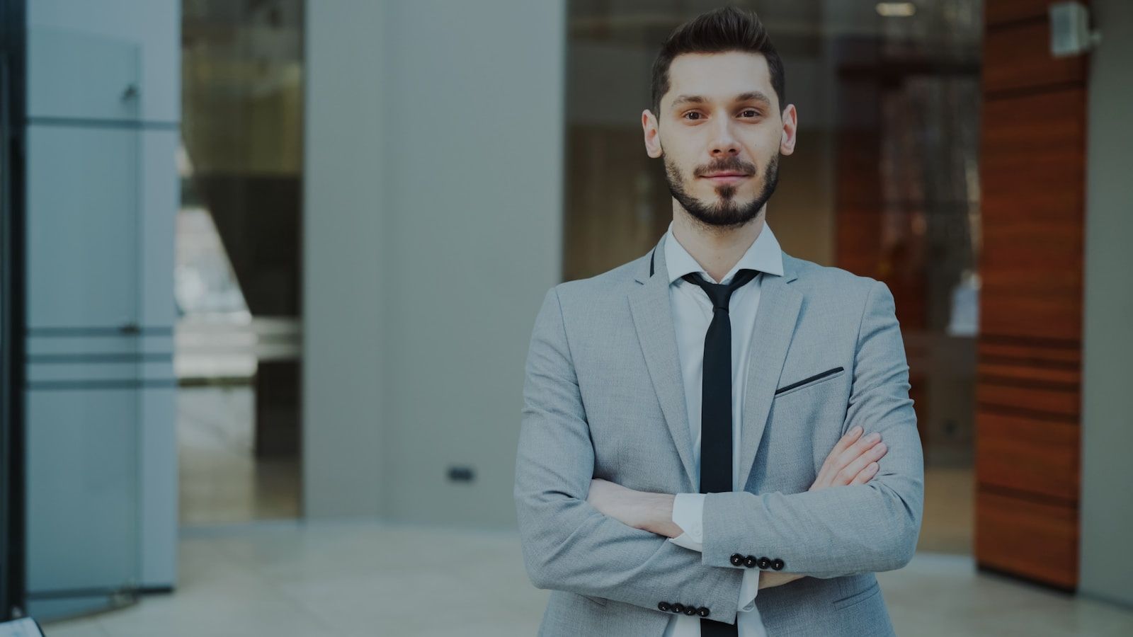 A security professional in business attire standing in a commercial building lobby