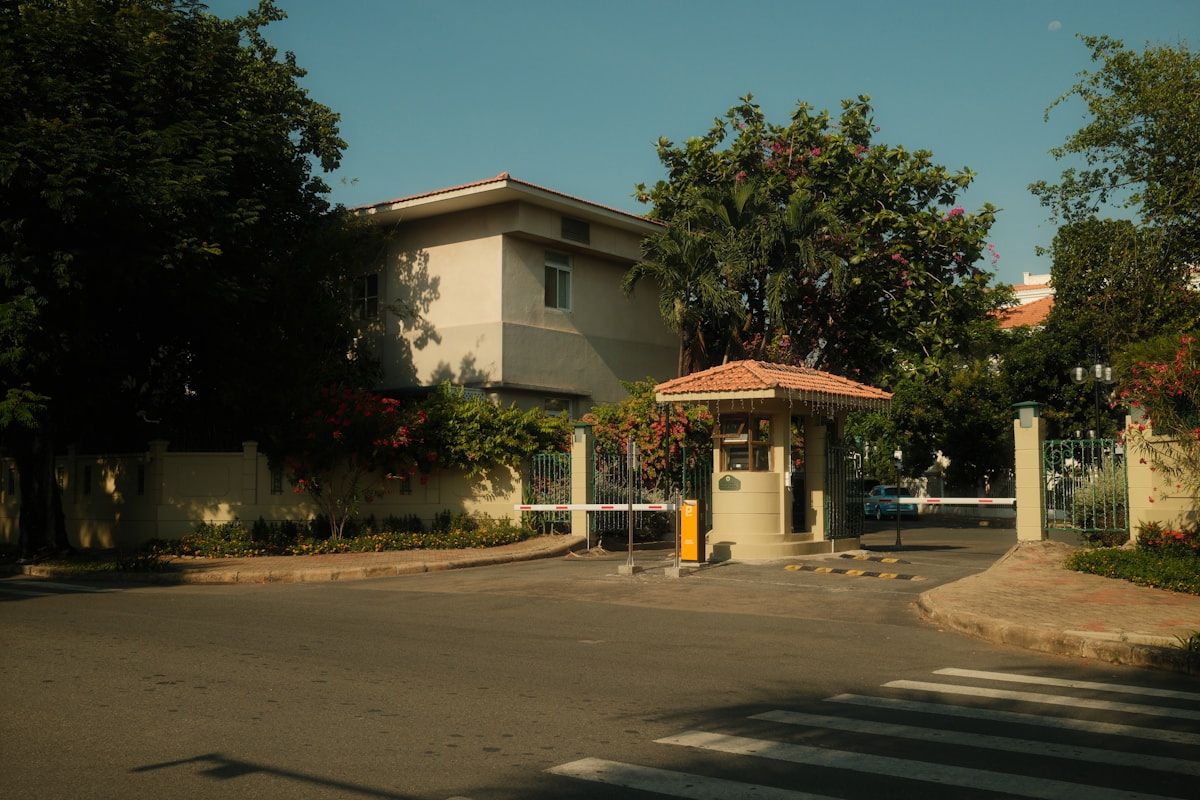 A gated residential community entrance with a booth and barrier arm
